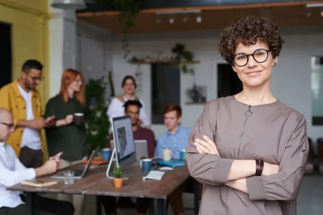 Woman smiling in front of her team of coworkers